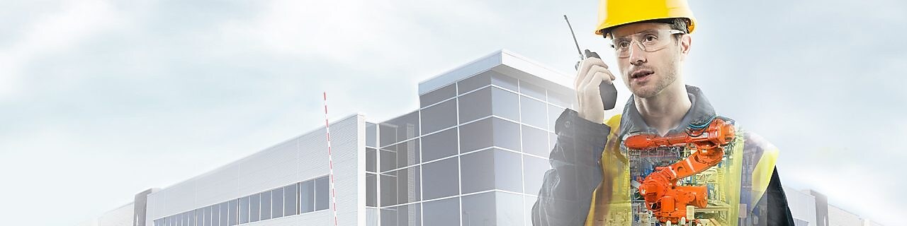 un homme portant un casque jaune parlant dans une radio transposé sur un fond montrant un grand bâtiment