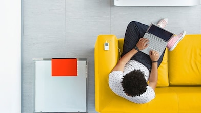 A man with laptop sitting on sofa