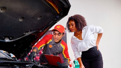 Cliente e mecânico Shell junto ao motor de um automóvel
