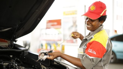 An enginner pours Shell lubricant into a car engine