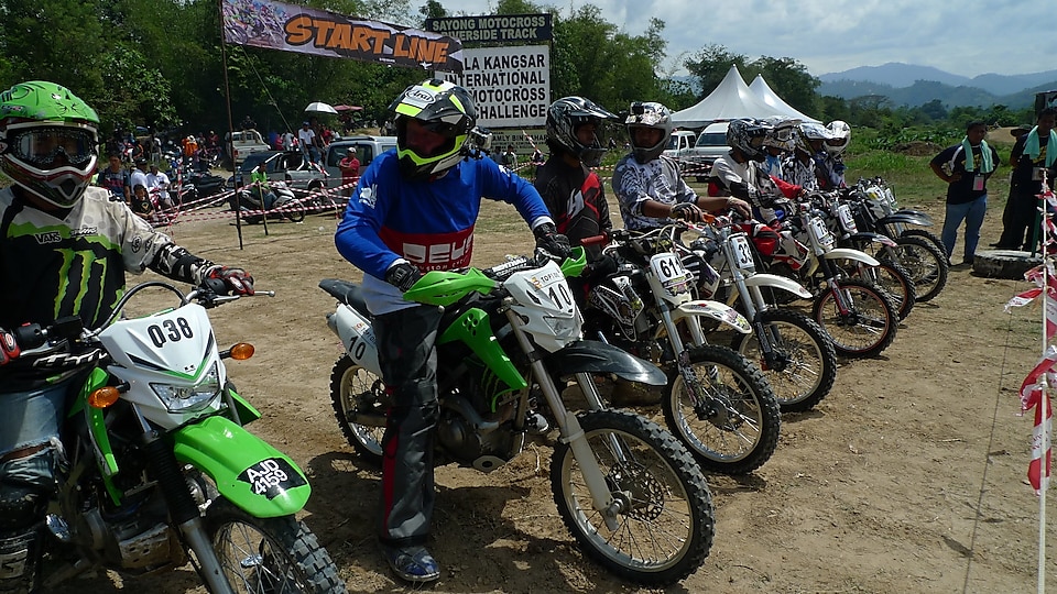 Motorcross motorcycles lining up at the start of a race